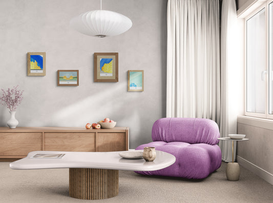 Quatre affiches picturales immeubles Paris dans un salon avec fauteuil en tissu rose design