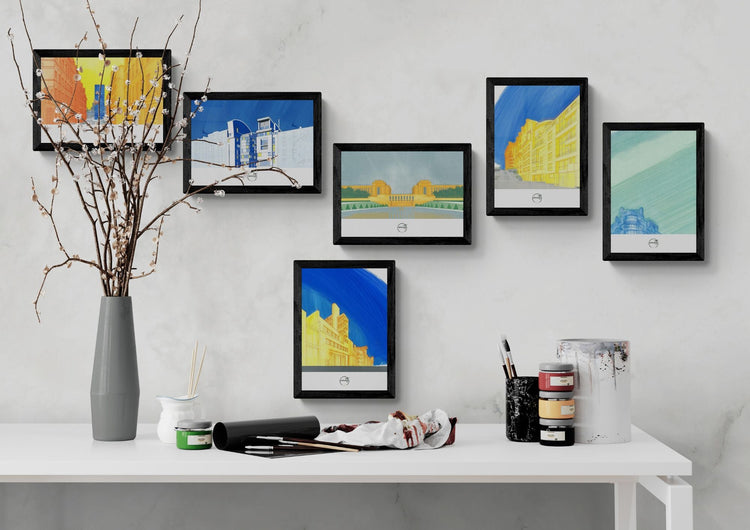 6 affiches architecture parisienne accrochées au-dessus console avec pinceaux et pots de peinture, décoration artistique