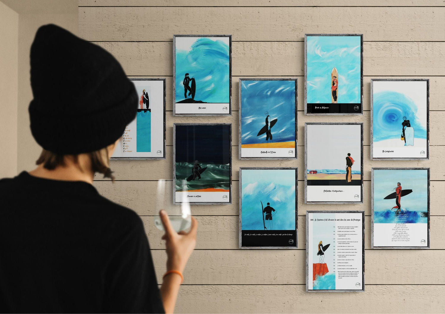 Collection 10 affiches surf BEFORE SURFING exposées sur mur de bois. Femme admirant décoration murale inspirée culture surf et océan.
