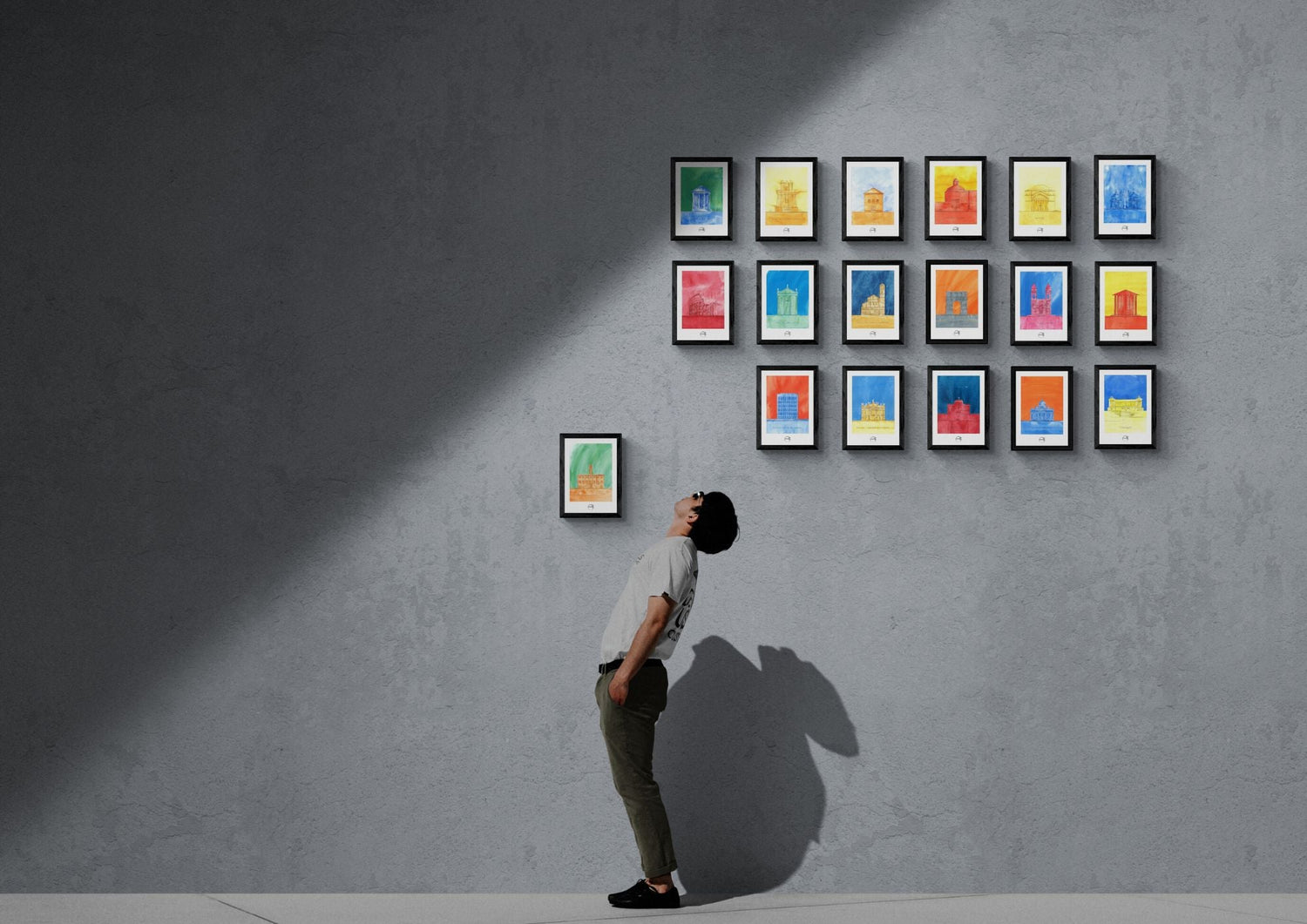 Collection de 18 affiches picturales colorées d'architecture romaine exposées sur un mur et un homme regardant cette collection