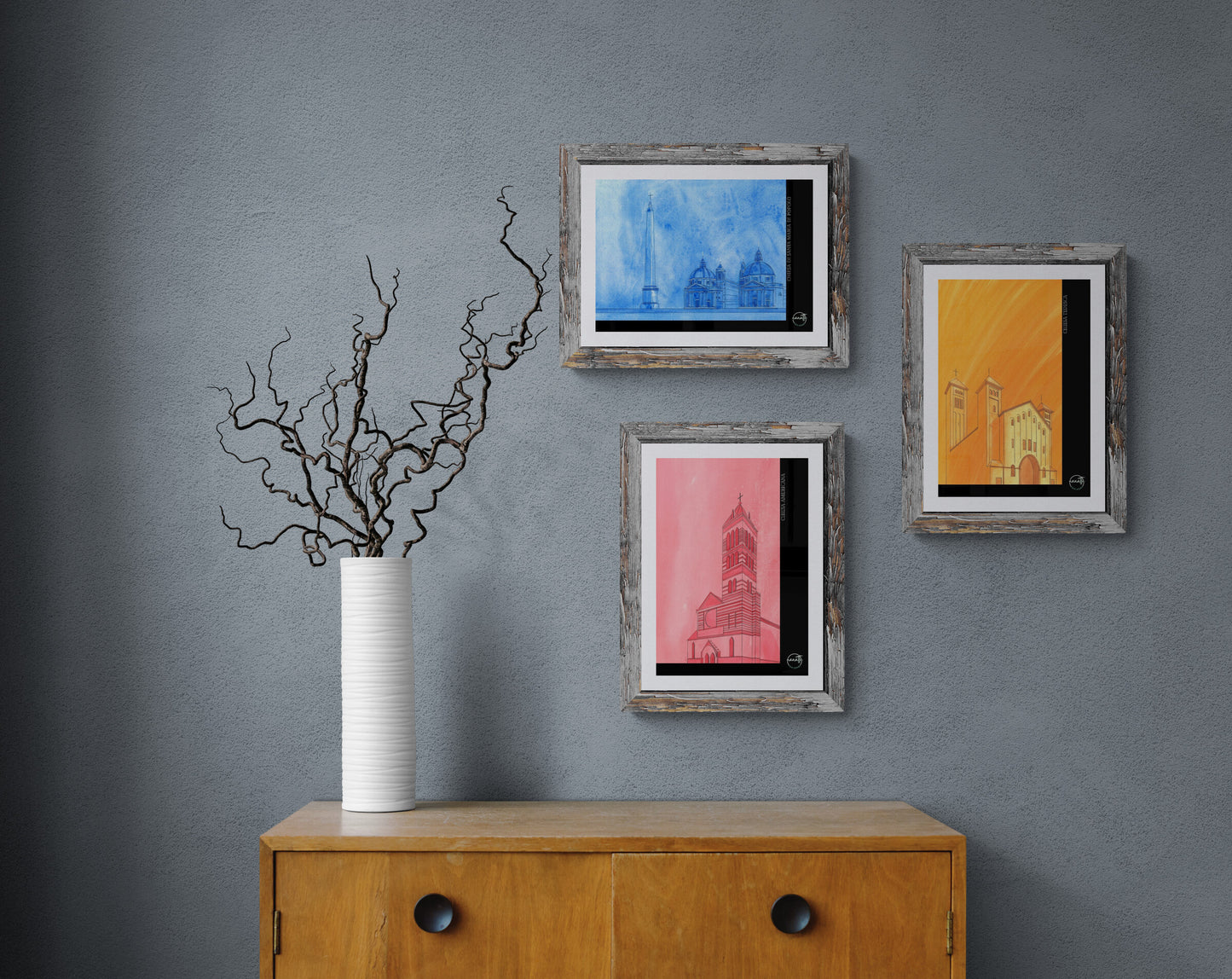 Trio affiches picturales églises romaines au-dessus d'un meuble bois avec vase et brindilles
