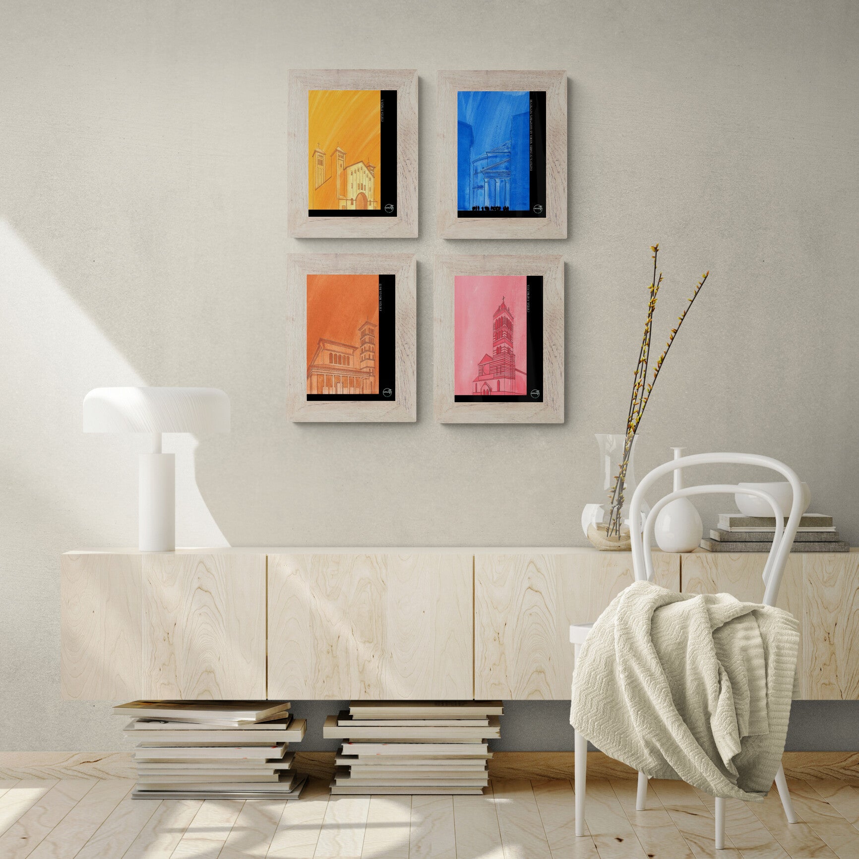 Quatre affiches picturales églises romaines au-dessus d'un buffet en bois blanc contemporain avec lampe et chaise