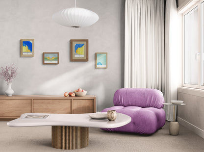 Quatre affiches picturales immeubles Paris dans un salon avec fauteuil en tissu rose design