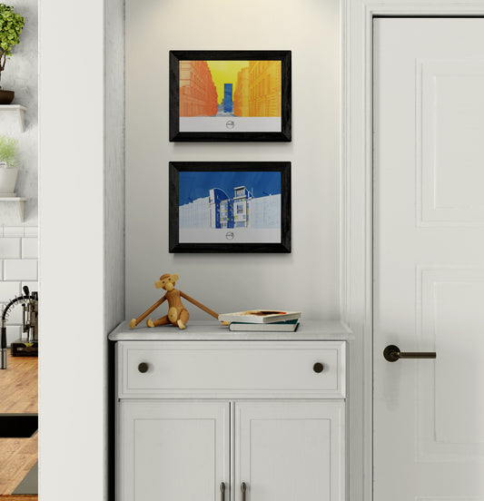 Deux affiches picturales architecture parisiennes dans entrée au-dessus d'un buffet en bois blanc