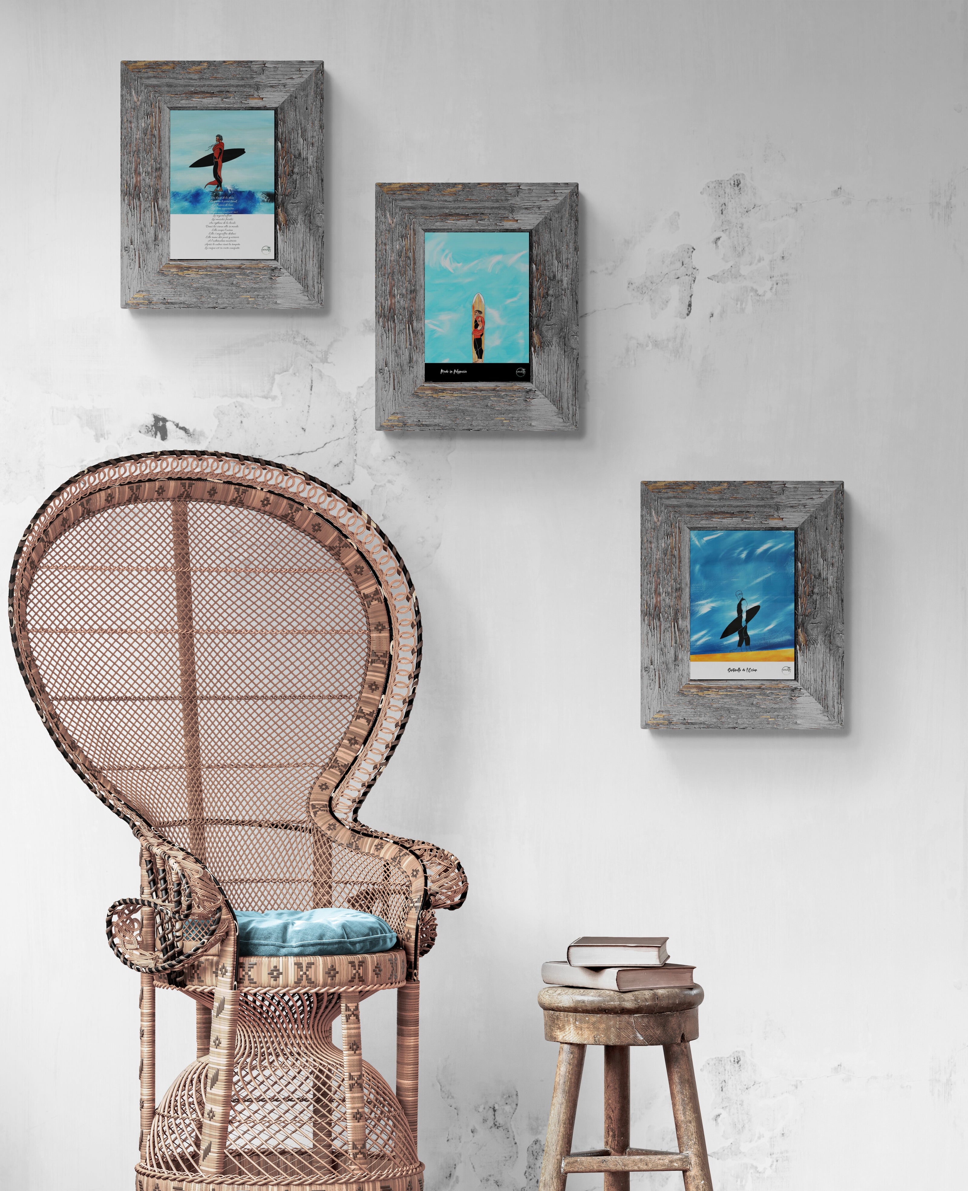 Trio d'affiches surf sur un mur blanc  au-dessus d'un  grand fauteuil en osier